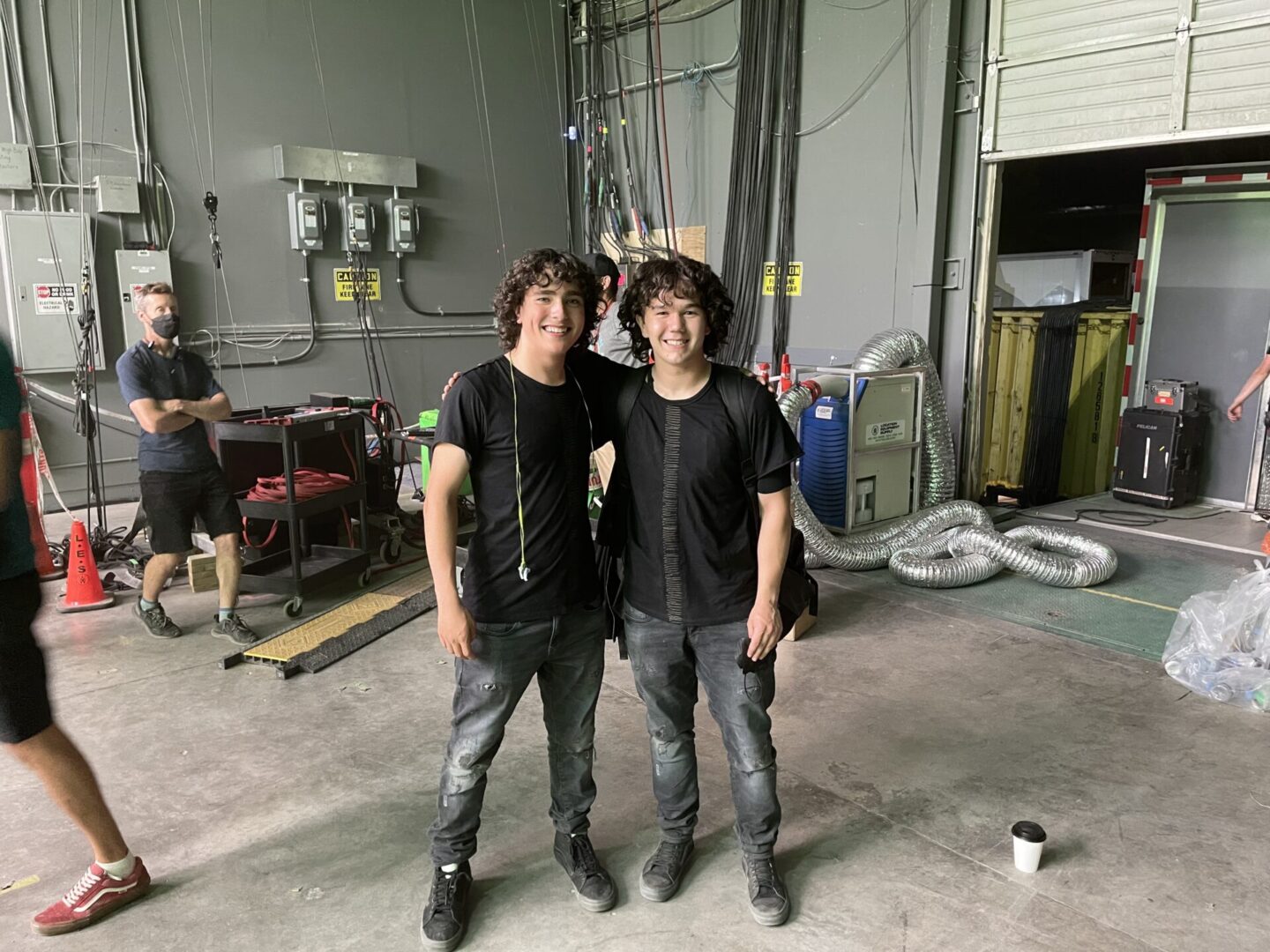 Two men standing next to each other in a warehouse.