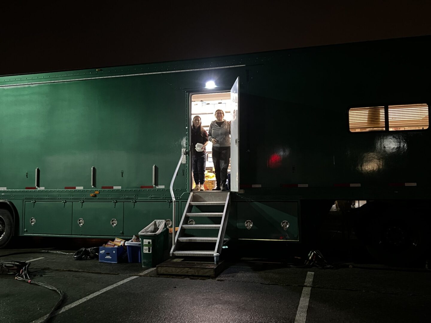 A couple is standing on the steps to their trailer.